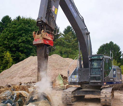 Bagger zerkleinert Schutt